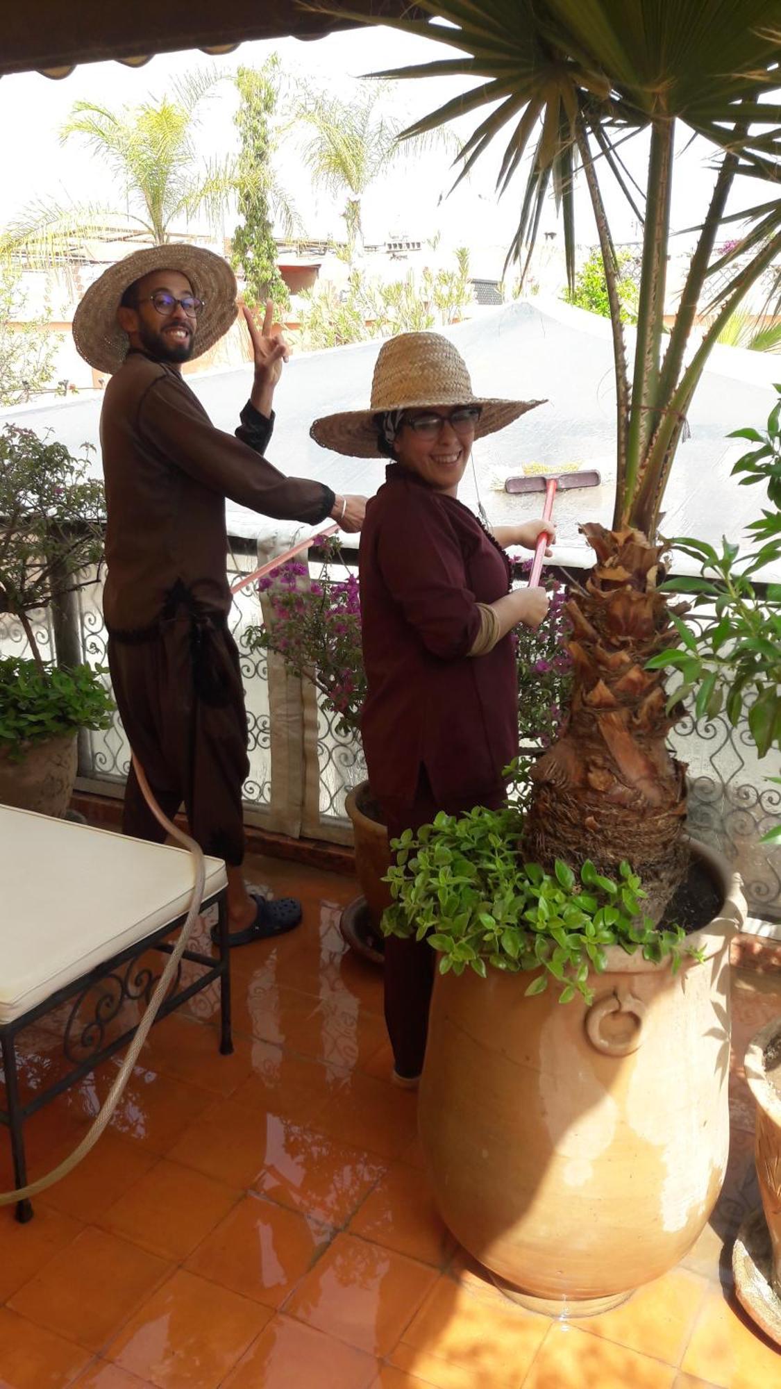 Riad Les Nuits De Marrakech Marrakesh Bagian luar foto A woman watering a plant